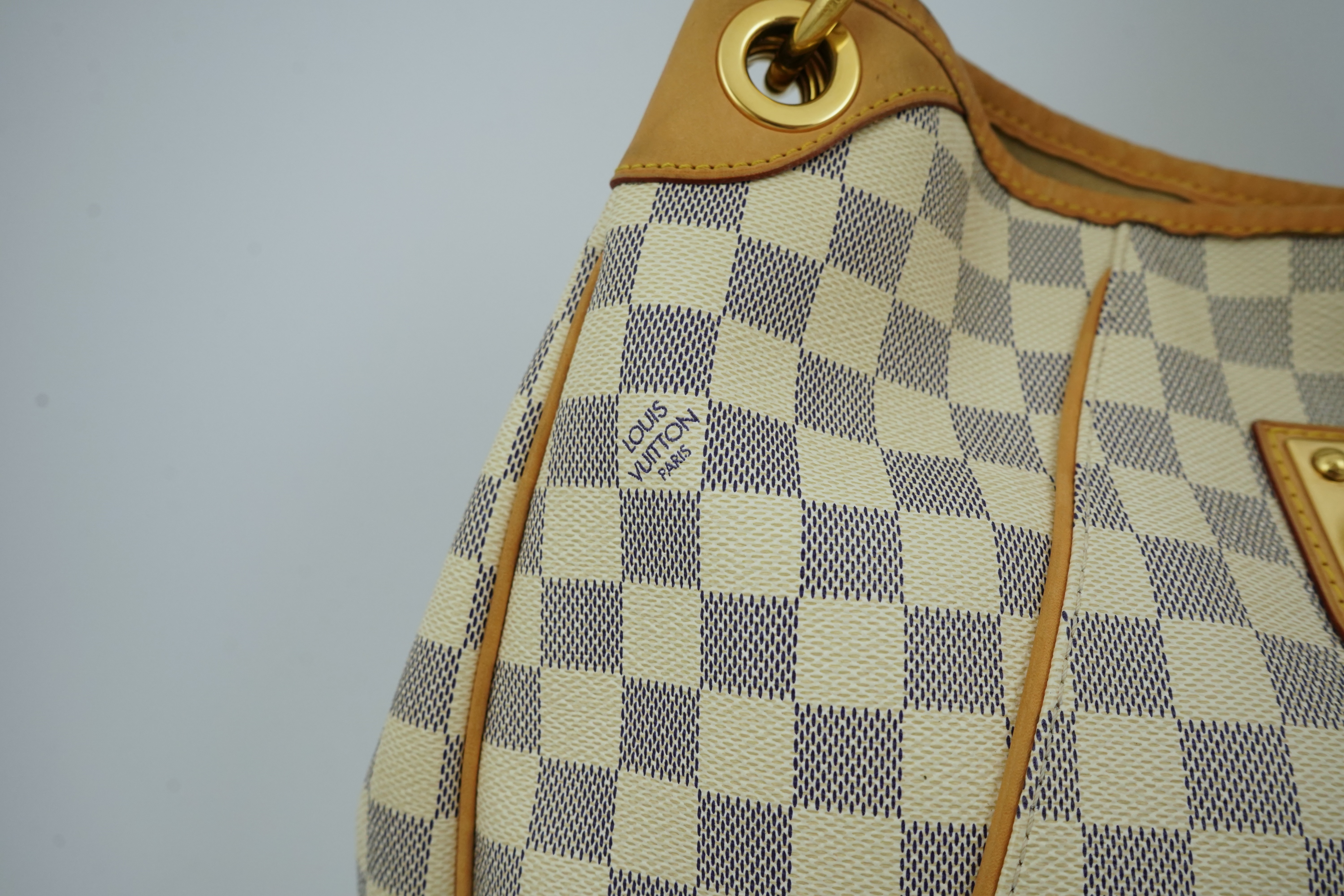 A Louis Vuitton handbag made from Damier Azur canvas with natural cowhide trim